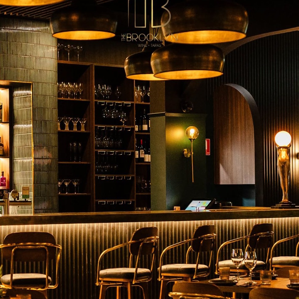 The bar counter with brass stools and the wine wall