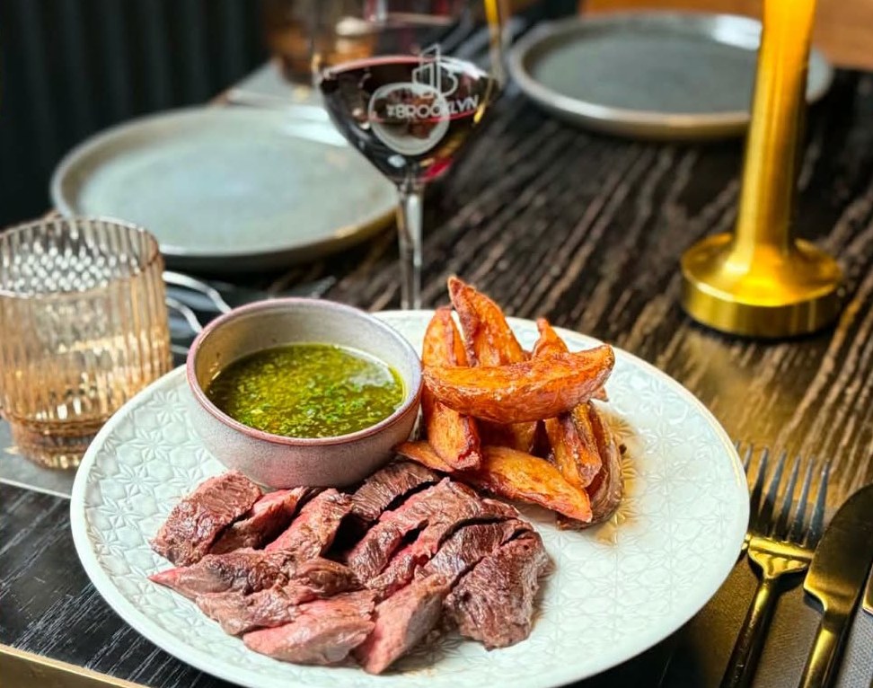 Steak Night at The Brooklyn: sliced steak, chimichurri and wedges with red wine